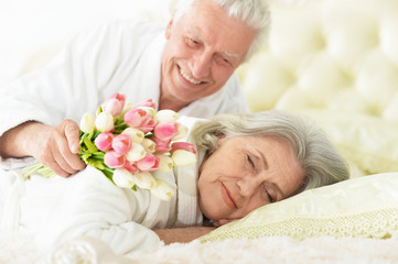 senior man gives flowers to a woman