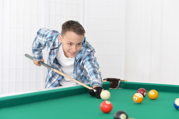 cute boy playing billiard