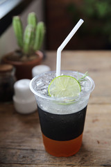 Ice tea with honey and lemon on wooden table