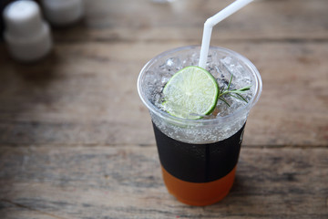 Ice tea with honey and lemon on wooden table