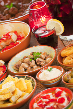 Assortment of Spanish tapas and sangria on a rustic table