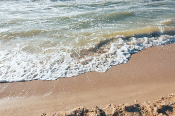 Turquoise sea wave foam on beach. Beautiful water nature. Perfect summer resort for relax. Sea waves near beach. Beautiful sea beach. Summertime, blue sea and waves, yellow sun and sand.