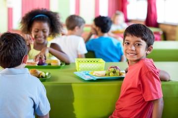 Boy with classmates having meal