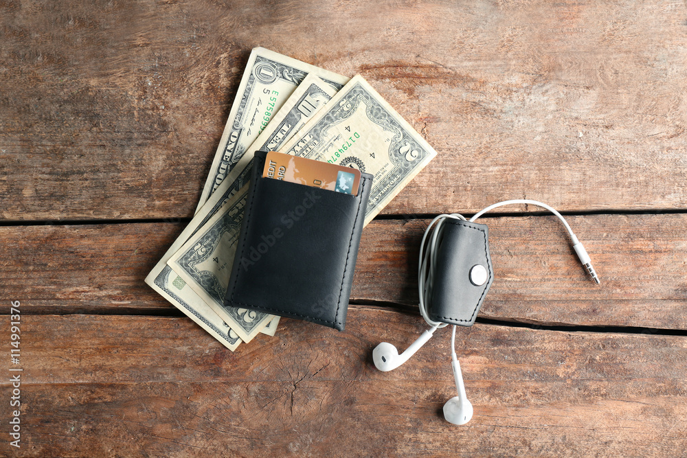 Poster Leather wallet with money and accessories on wooden table