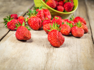 Fresh strawberries was scattered on a wooden table surface