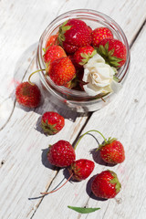 strawberries in a glass jar on old boards