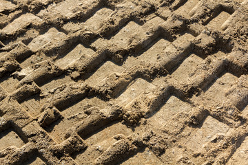 Background with footprints in the sand of heavy machinery