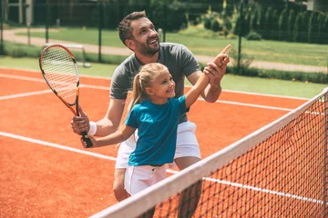 Tennis is fun when father is near. © gstockstudio