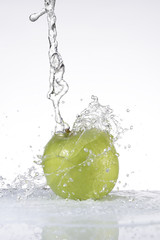 Agua cayendo sobre una manzana verde