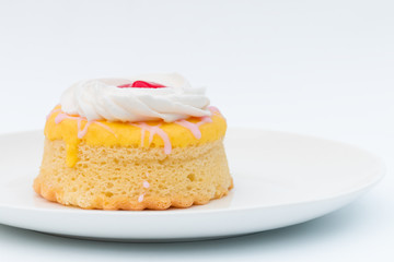 Butter cake with strawberry jam and whipped cream on a white background.