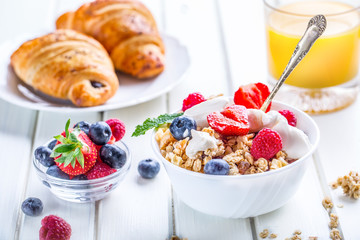 Muesli with yogurt and berries on a wooden table. Healthy fruit and cereal brakfast.