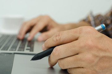 Artist drawing on graphic tablet with laptop computer
