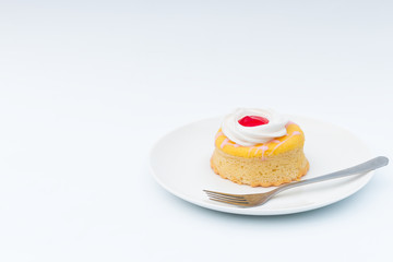 Butter cake with strawberry jam and whipped cream on a white background.