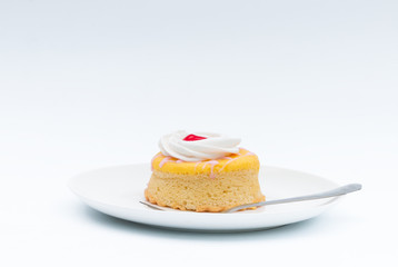 Butter cake with strawberry jam and whipped cream on a white background.