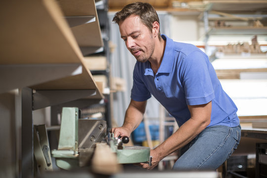 Man working on clamp tool in workshop