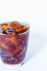 Cola in glass with ice on white background