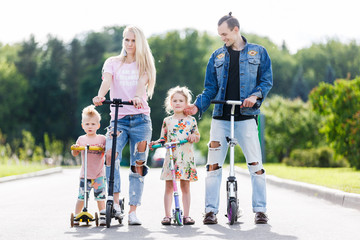 Family with scooters in the park © snedorez