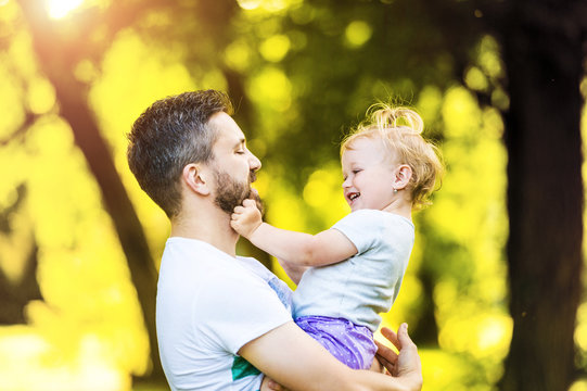 Father holding little daughter on his arms