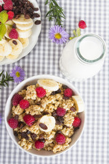 granola with fruits and bottle of fresh milk
