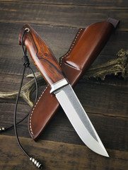 hunting knife handmade on a wooden background