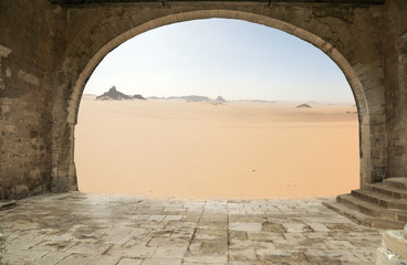 Old architectural arch in the background of the desert.