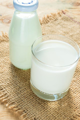 A glass of rustic milk and bottle glass of rustic milk and ear o
