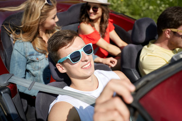 Obraz premium happy friends driving in cabriolet car