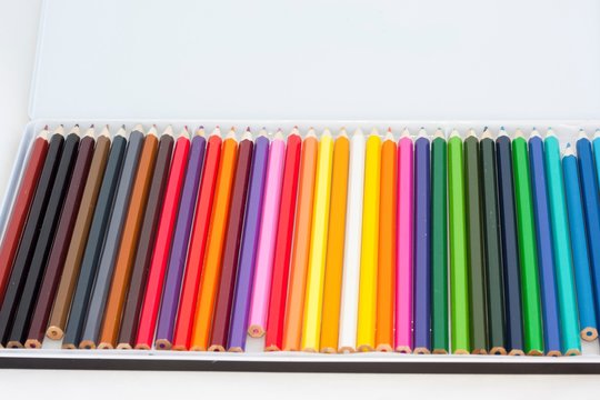 Set of colored pencils in a box on a white background
