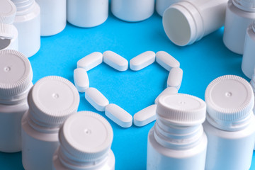Many pills and tablets isolated on light blue background