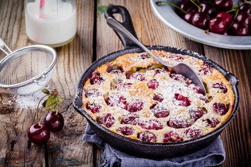 Clafoutis cherry pie on  wooden background