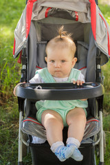 little girl sitting in a baby carriage