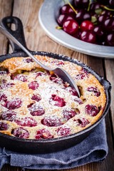 Clafoutis cherry pie on  wooden background