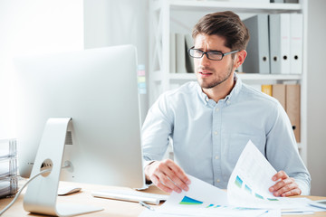 Businessman working with documents and computer in office
