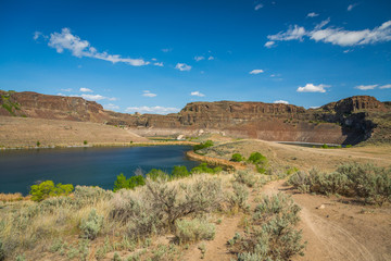 Lake in the rocks. Dry plants on the lake. Ancient Lakes trail, Eastern Washington, Spring