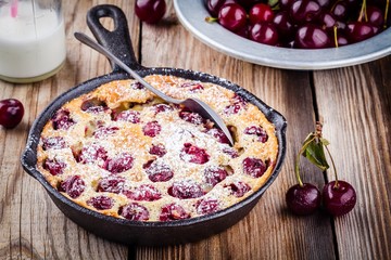 Clafoutis cherry pie on  wooden background