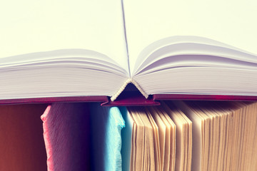 Open book, stack of colorful hardback books on light table. Back to school. Copy space for text