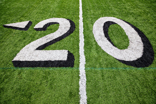 20 yard line on a green football field with white lettering