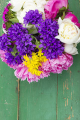 bouquet of colorful flowers on green wooden planks