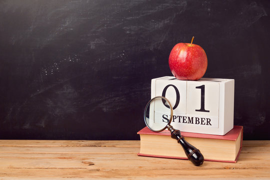 Back To School Background With Book, Apple And Calendar Over Chalkboard