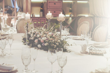 Blurred background wedding celebration wallpaper, floral. Elegance table set in banquet restoraunt with elegant composition of beige roses, peony flowers. Text, copy space.