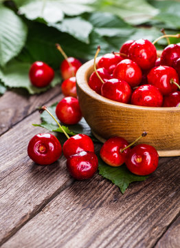 Fresh ripe cherries with jam on a wooden table.