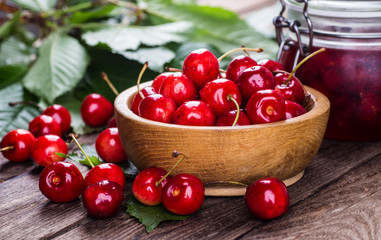 Fototapeta na wymiar Fresh ripe cherries with jam on a wooden table.