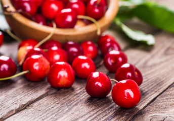 Fresh ripe cherries with jam on a wooden table.
