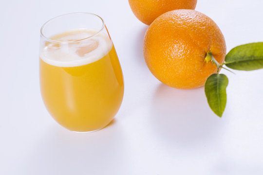 Fresh oranges and glass of orange juice.