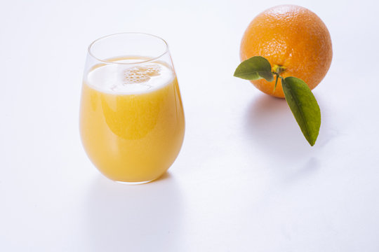 Fresh orange and glass of orange juice.