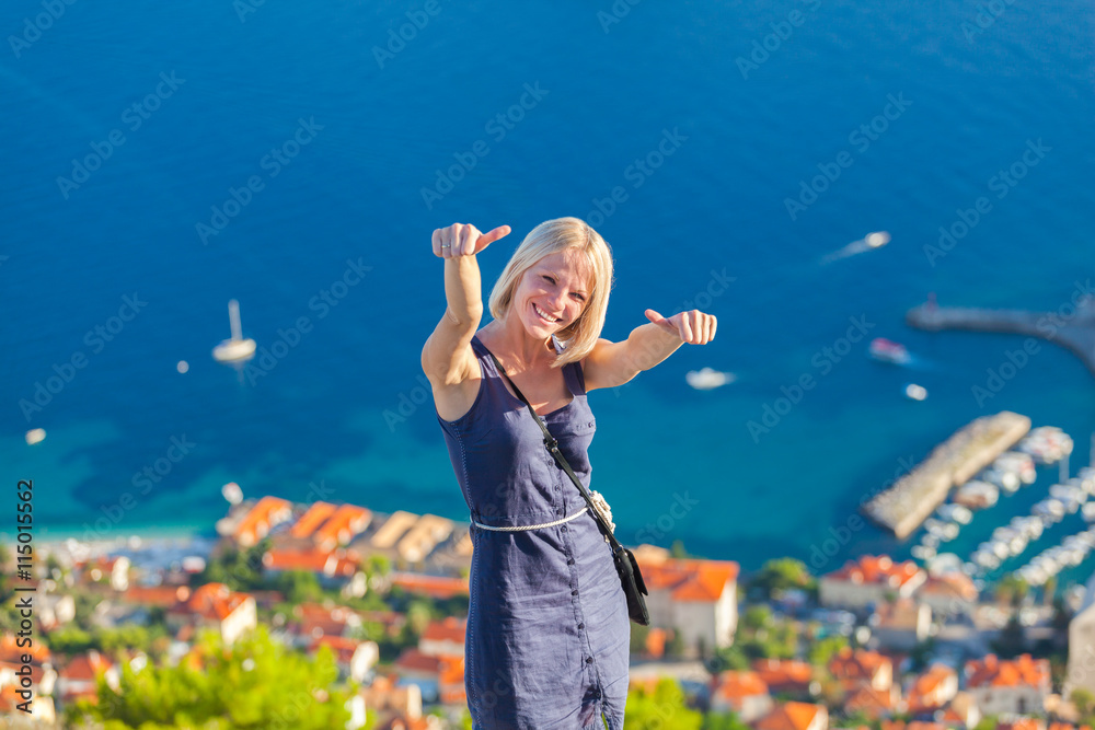 Wall mural young woman tourist looks to the old city of dubrovnik.