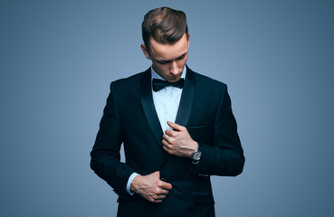 Handsome young man in a tuxedo looking at the camera. Fashionable Clothing. Clothing for the...