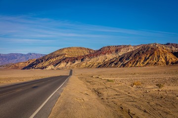 Fototapeta na wymiar Road through canyons with lots of different topography. The road offers majestic views. It contains colorful rock formation. Badwater rd, Death Valley National Park