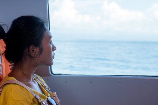 passenger on a ship looking out the window at the sea