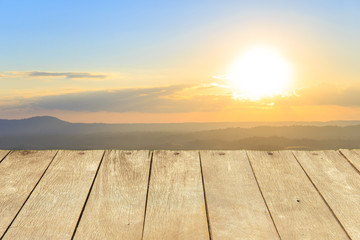 Fototapeta na wymiar Empty wooden table or plank with Sunset in mountains on background for product display.